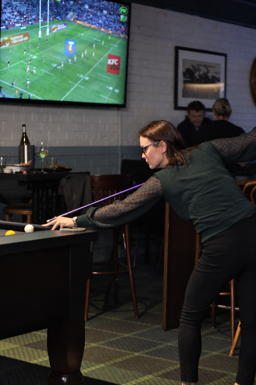 Person lining up a shot on a pool table